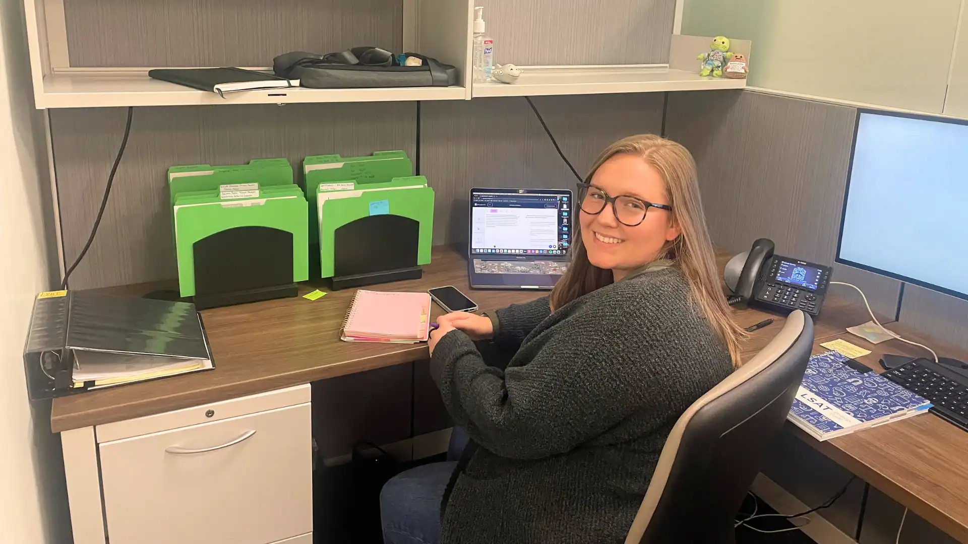 An intern posed smiling at her desk while working at CHS
