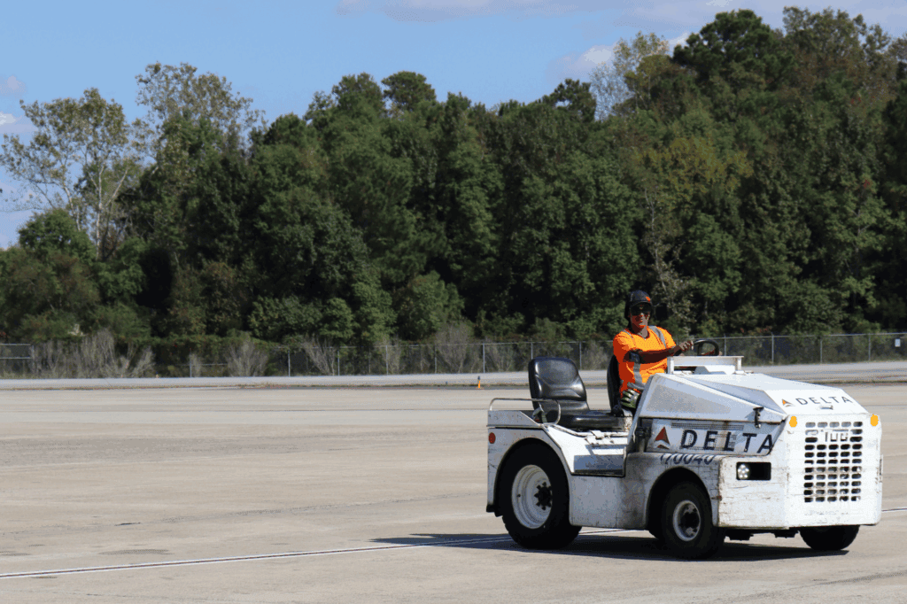 Man driving tug truck on airport tarmac